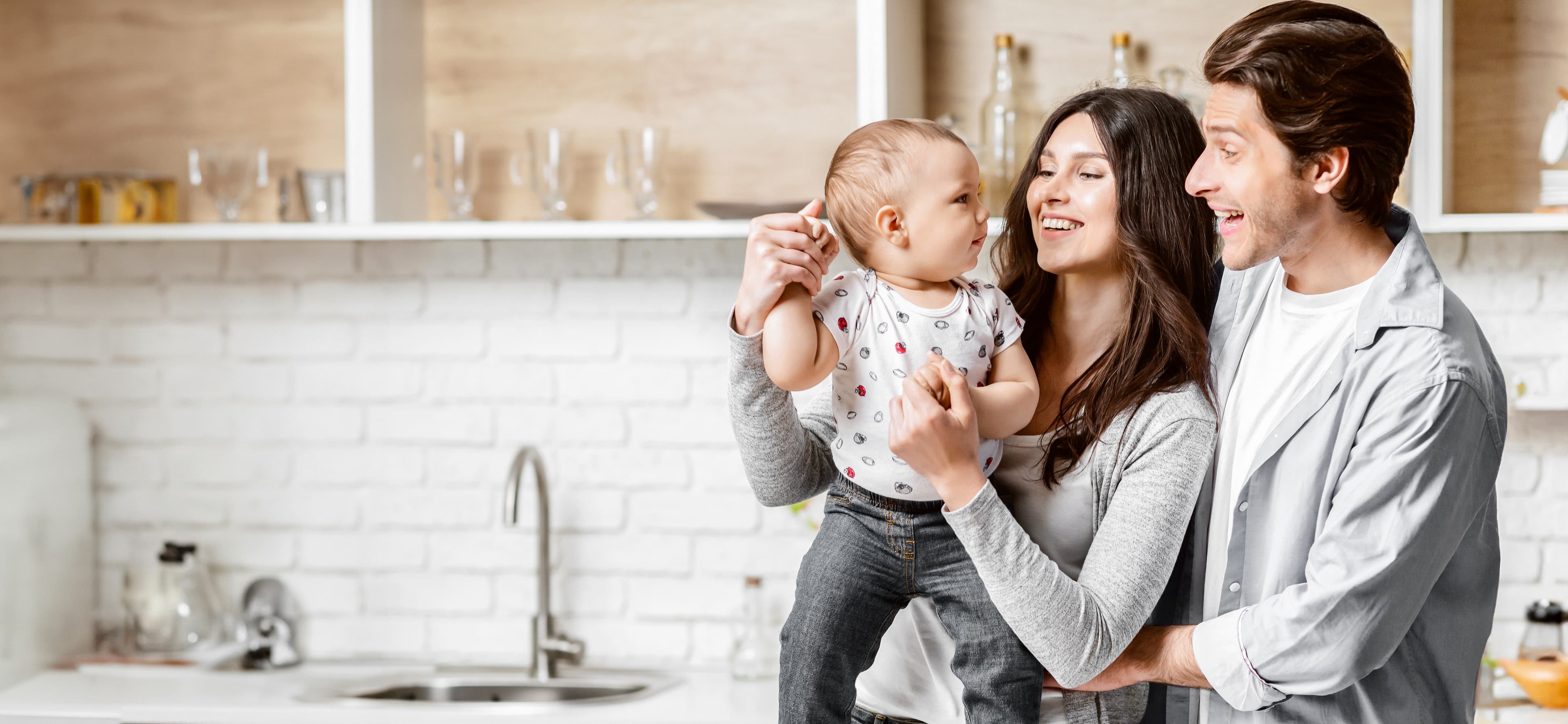 Family holding their baby in a bright kitchen